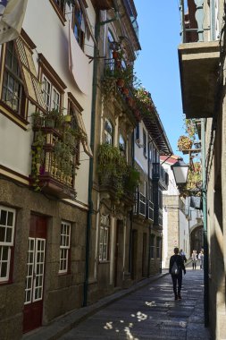 Guimaraes, Portekiz - 09: 30: 2022: Güneşli bir günde geleneksel Portekiz tarzında tarihi mimarisi olan Guimaraes şehir merkezindeki dar sokaklar.