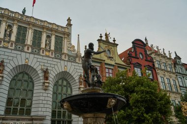 Gdansk, Pomerania, Polonya 'daki Neptün çeşmesi. Tarihi binaların önündeki eski Danzig kasabasında mızraklı bir Roma tanrısının heykeli ve çeşmesi..