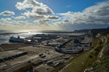 Dover, İngiltere - 02 26 2023: Dover feribot limanının ticari rıhtımı, İngiltere ve Fransa arasındaki Kent kanalı boyunca beyaz kayalıkların eteklerinde bir liman..