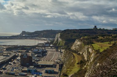 Dover, İngiltere - 02 26 2023: Dover feribot limanının ticari rıhtımı, İngiltere ve Fransa arasındaki Kent kanalı boyunca beyaz kayalıkların eteklerinde bir liman..
