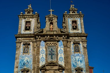 Porto, Portekiz - 10 23 2022: Portekiz kültürünün bir parçası olan Azulejo adı verilen geleneksel beyaz ve mavi fayanslar, Porto 'daki eski Aziz Ildefonso kilisesinin duvarlarını dekore ediyor..