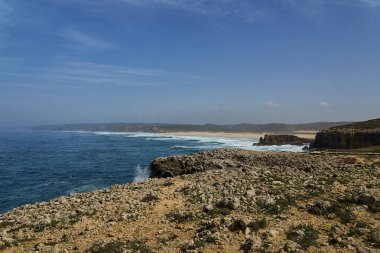 Praia Do Bordeira Plajı 'ndaki engebeli kayalıklar ve kumsallar Portekiz' in Algarve bölgesindeki Atlantik Okyanusu 'nun kayalık kıyı şeridi boyunca ünlü bir sörf noktası..
