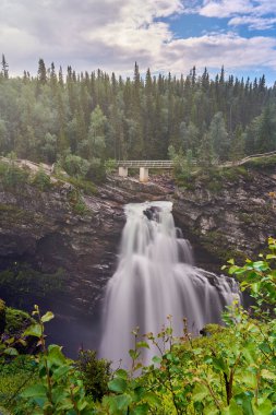 İsveç 'te Hallingsafallet şelalesi, popüler turistik güzergah boyunca Vildmarksvagen, İskandinavya' nın sık ormanlarından geçen ıssız yol..