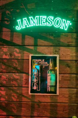 Vilnius, Litvanya - 06 28 2023: Litvanya 'da popüler bir seyahat merkezi olan Vilnius' un tarihi eski kasabasında Jameson Irish Whiskey markasının yeşil ışıklı işareti.