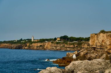 Lizbon 'daki Atlantik Okyanusu' nun kayalık kıyı şeridi, Portekiz 'in başkenti Tagus nehrinin ağzında, Güney Avrupa' nın güneşli bir gününde okyanusun mavi suyuyla..