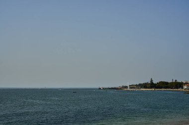 Lizbon 'daki Atlantik Okyanusu' nun kayalık kıyı şeridi, Portekiz 'in başkenti Tagus nehrinin ağzında, Güney Avrupa' nın güneşli bir gününde okyanusun mavi suyuyla..