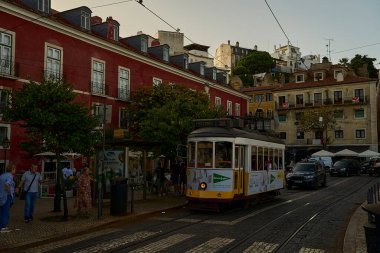 Lizbon, Portekiz - 10 7 2022: Lizbon sokaklarındaki tipik eski sarı vintage tramvay dar sokaklarda ilerliyor.