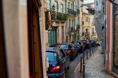 Lizbon, Portekiz - 10 7 2022: Lizbon sokaklarındaki tipik eski sarı vintage tramvay dar sokaklarda ilerliyor.