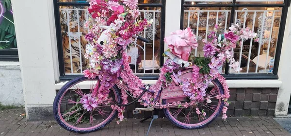 ピンク色の花々がたくさん飾られた自転車 — ストック写真