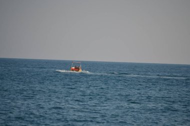 Geniş denizde, gün ışığında dalgalı bir spor teknesi.