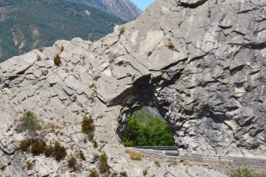 Kayadaki bir delikten geçen bir yol.