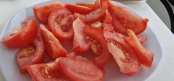 Sliced tomatoes for a tomato salad in a white plate