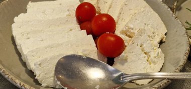 Sliced tomatos with herbs in a white pot clipart