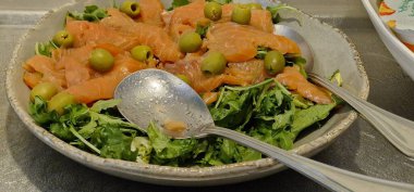 Somon ve zeytin parçalı salata yaprakları.