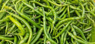 Sivri uçlu biberler, büyük bir yığın içinde uzatılmış yeşil.