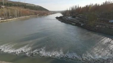 Küçük bir şelalesi ve ormanlık kıyıları olan bir nehir.
