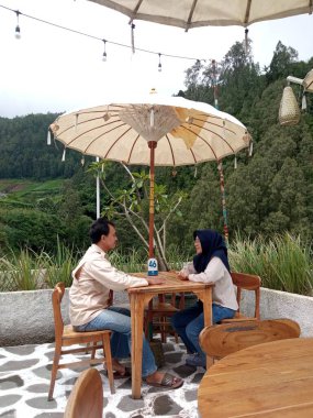 Bir çift açık bir kafede öylesine sohbet ediyor.