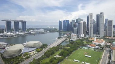 Marina Bay Singapur şehrinin ufuk çizgisindeki bulutlu manzara hava görüntüsü. Sola çevir