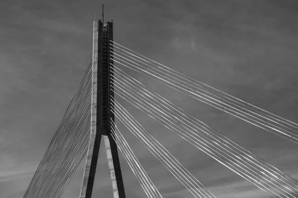 天空背景下斜拉桥支撑物和金属电缆的黑白照片摘要 — 图库照片