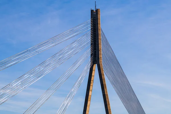 Central support of cable-stayed bridge with anchoring cables on blue sky background.