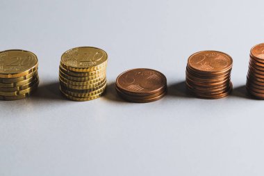 Stacks of coins arranged in a row. Euro coins and cents.