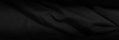 Dark background from a wavy fabric texture. Wide panoramic black background with space for design. Web banner, website header.