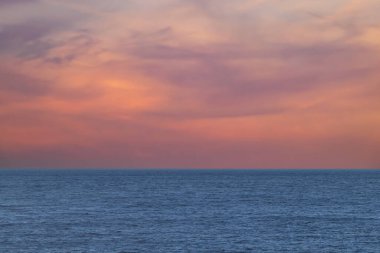 Gün batımında güzel bir turuncu gökyüzü olan geniş bir deniz manzarası. Yazmak için boş alan, kopyalamak için boşluk..
