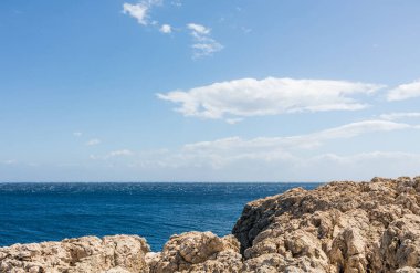 Uçurumdan deniz manzarası. Mavi gökyüzü ve arkaplanda beyaz bulutlar olan deniz manzarası.