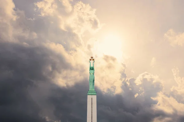 Stock image Latvian Freedom Monument, cloudy sky with sun in the background. Riga, Latvia