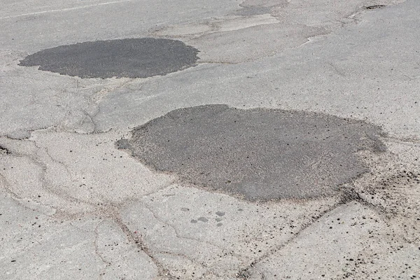 在一条崎岖崎岖的柏油路上的补丁 沥青路面修理 — 图库照片
