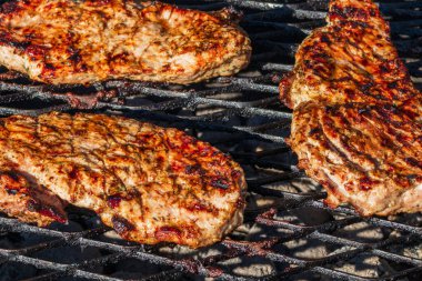 Izgara domuz bifteği. Kömürde ızgara bifteklerin yakın çekimi. Izgara, ızgarada kahverengi et, bbq.