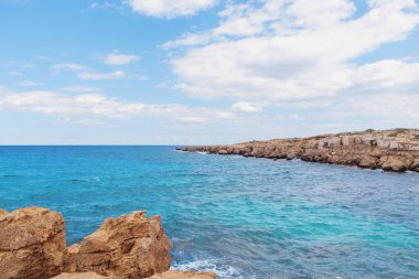 Nature landscape of the blue lagoon between the rocky bay, blue sky with white clouds in the background.