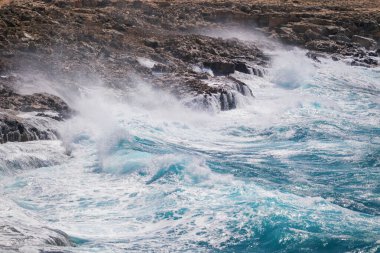 Büyük okyanus dalgaları kıyıdaki kayalara çarpıyor..