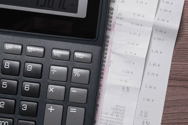 Black calculator and purchase receipts, invoices. Concept on the topic of expenses, family budget, daily bills.