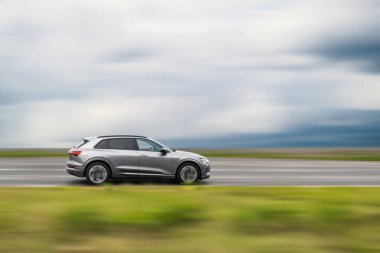 Gri araç hareket halinde, hızı bulanık arkaplan, metin için boş alanı olan hareket halindeki arabanın yan görünümü