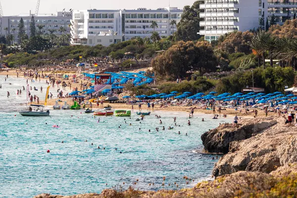 Turkuaz suyu ve tatilcileri olan Sandy Akdeniz plajı. Glyki Nero ve Pantachou Plajı, Ayia Napa, Kıbrıs - 20 Ekim 2023.