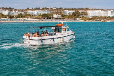 Kıbrıs Rum Kesimi 'nin Ayia Napa kentinde turistlerle dolu bir tekne. Akdeniz 'deki mavi göle bir gezinti. Ayia Napa, Kıbrıs - 20 Ekim 2023.