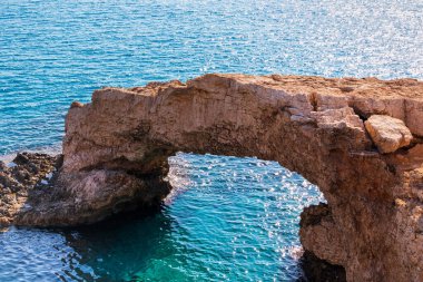 Suyun üstünde, denizde taş bir kemer. Popüler bir turizm merkezi. Aşıklar Köprüsü, Ayia Napa, Kıbrıs.