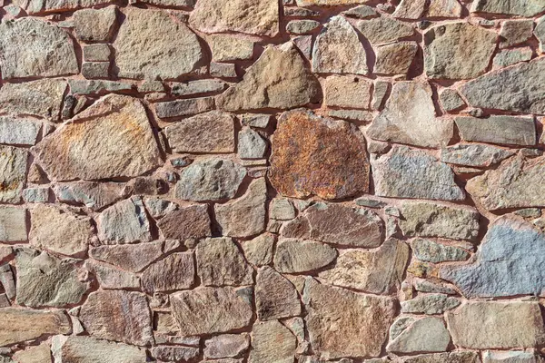 Stone wall texture. The background of the wall is made of stones of different sizes.