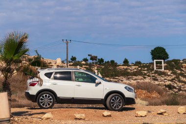 Araba kayalık arazide. Dağlarda beyaz SUV arabası, yan görüş.