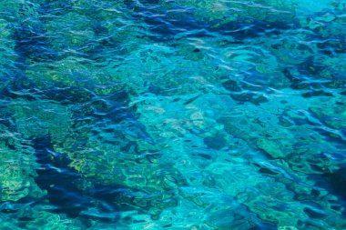 Abstract background with blue sea water. Wavy turquoise water texture on a sunny day.