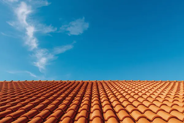 Clay tile roof. Orange clay tile roof close-up with blue sky in background with free space for text, copy space.