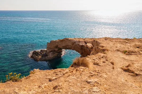 View of the stone arch entering the sea. A popular tourist destination. Lovers\' Bridge, Ayia Napa, Cyprus.