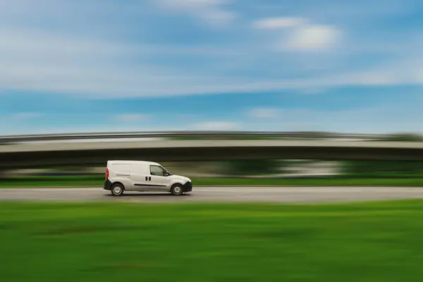 stock image Small cargo van drives down the street.