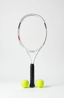 İki sarı tenis toplu tenis raketi, düz beyaz arka planda. Spor, eğlence, açık hava aktiviteleri, egzersiz veya ekipman ile ilgili kavramları göstermek için idealdir.