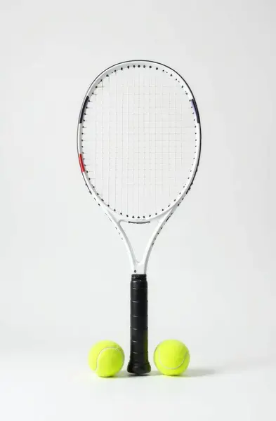 İki sarı tenis toplu tenis raketi, düz beyaz arka planda. Spor, eğlence, açık hava aktiviteleri, egzersiz veya ekipman ile ilgili kavramları göstermek için idealdir.