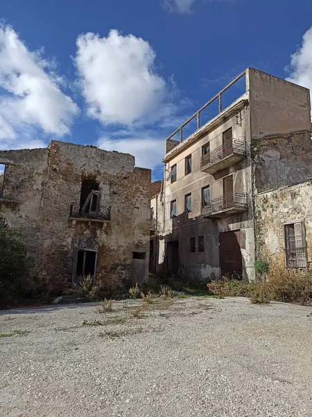Poggioreale, Sicilya 'da yıpranmış duvarları ve aşırı gelişmiş bitki örtüsü olan terk edilmiş binalar, kentsel çürümeyi ve ihmalkarlığı ön plana çıkarıyor.