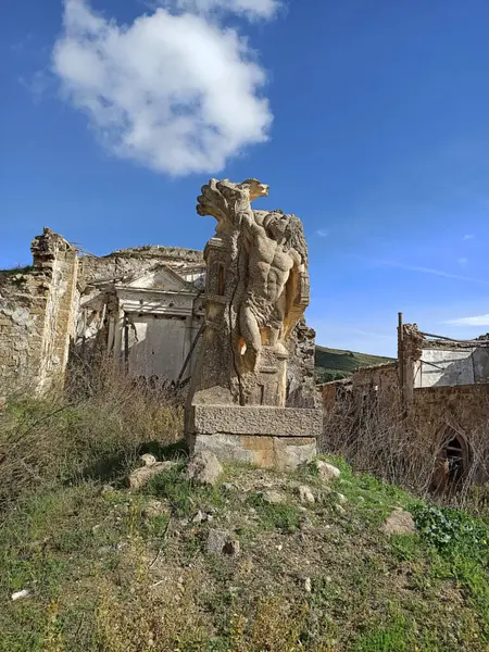 Sicilya Poggioreale harabeleri arasında tarihi mimari ve doğal güzelliğin karışımını vurgulayan antik bir heykel sergileniyor.