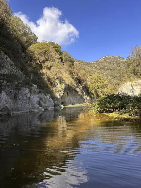 Gole Di Tiberio, İtalya - 02 Kasım 2024: Serene Nehri manzarası berrak mavi gökyüzünün altında canlı yeşillikler ve kayalık uçurumlar sergiliyor