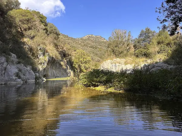 Gole Di Tiberio, İtalya - 02 Kasım 2024: Serene Nehri manzaraları, açık mavi gökyüzünün altındaki yemyeşil ve kayalık uçurumlar güzellikleri yansıtıyor